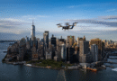 Aerial view of Manhattan skyline with One World Trade Center; a small helicopter in the sky above the buildings.
