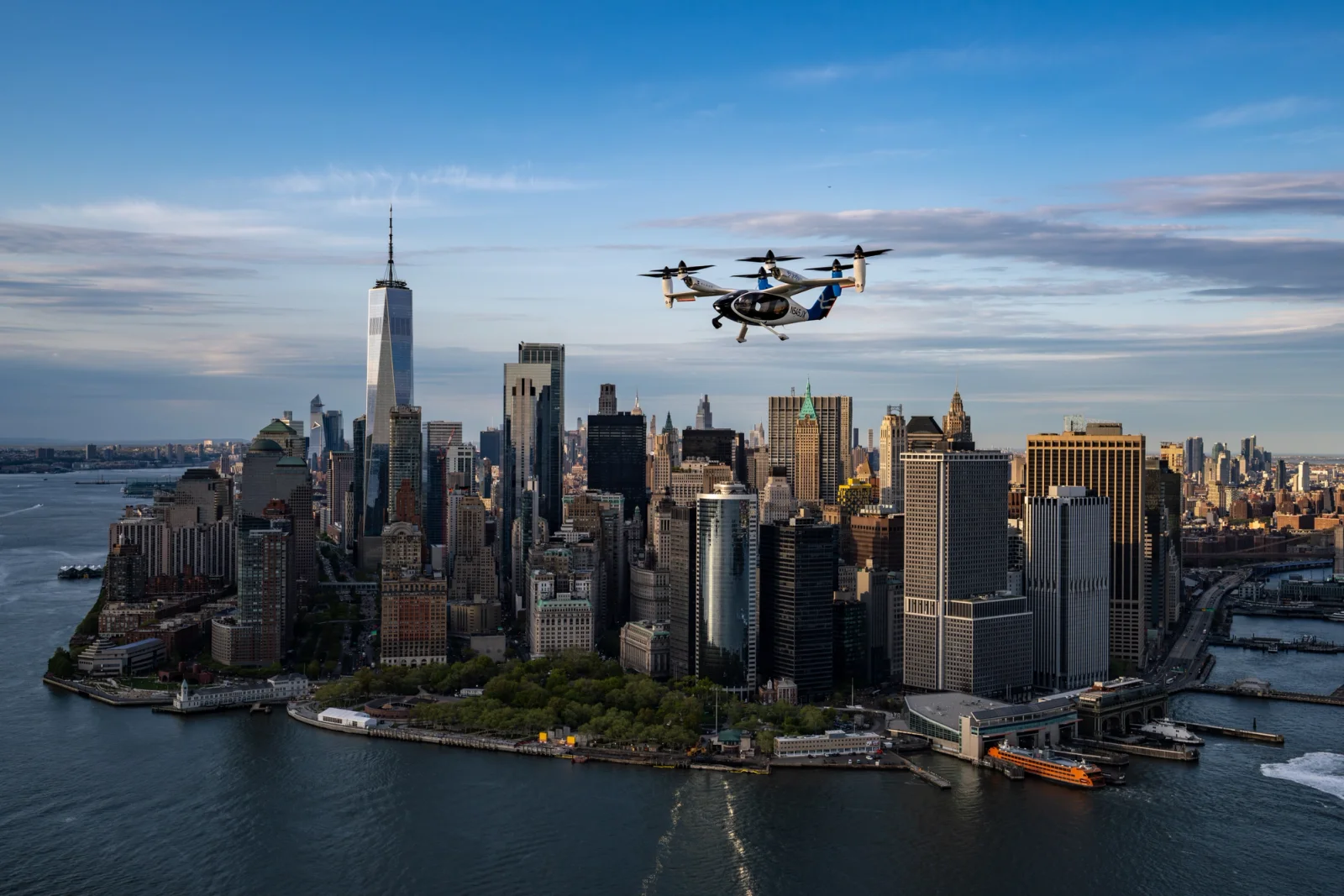 Aerial view of Manhattan skyline with One World Trade Center; a small helicopter in the sky above the buildings.