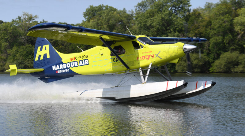 Colorful seaplane taking off from water, bright yellow and blue Harbour Air aircraft lifting above the surface.