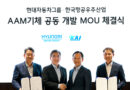 99fb0d9e63634ab7a02829595354ac3a - eVTOL Insights Four executives in suits celebrate a MOA signing between Hyundai Motor Group and KAI, holding signed documents under a Korean banner and logos above.