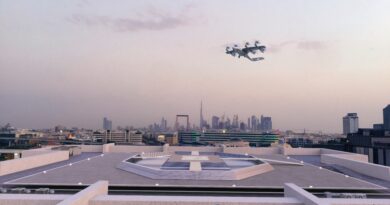 Aircraft in formation flying above a city skyline seen from a rooftop with a futuristic platform and the Aeroberm logo on the building facade