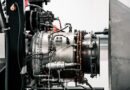 Close-up of an industrial engine with hoses, pipes, and metallic components in a mechanical setup.