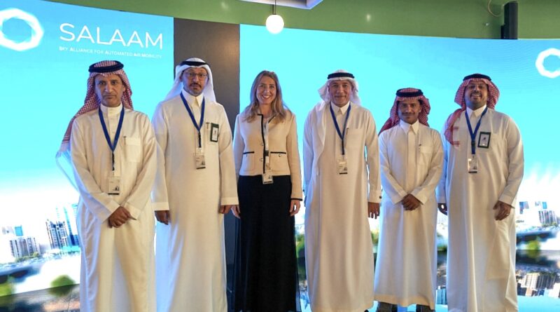 SALAAM_Roundtable - eVTOL Insights Group of six people in traditional white robes posing on a blue Salaam backdrop at an event.