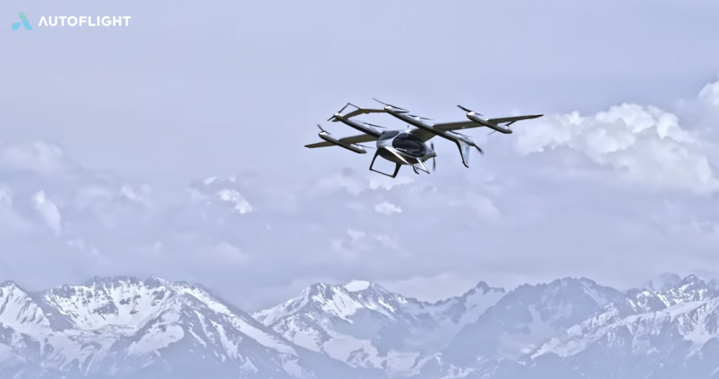 Screenshot 2026-05-21 at 095759 - eVTOL Insights Autoflight drone flying in a pale blue sky above snow-capped mountains, logo visible in the top-left corner.