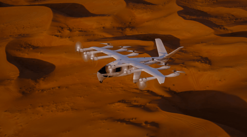 White tilt-rotor aircraft flying low over orange desert sand dunes.