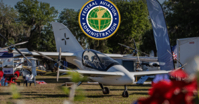 FAA emblem reading 'Federal Aviation Administration' hovering above a display of small aircraft at an outdoor airshow/aviation event.