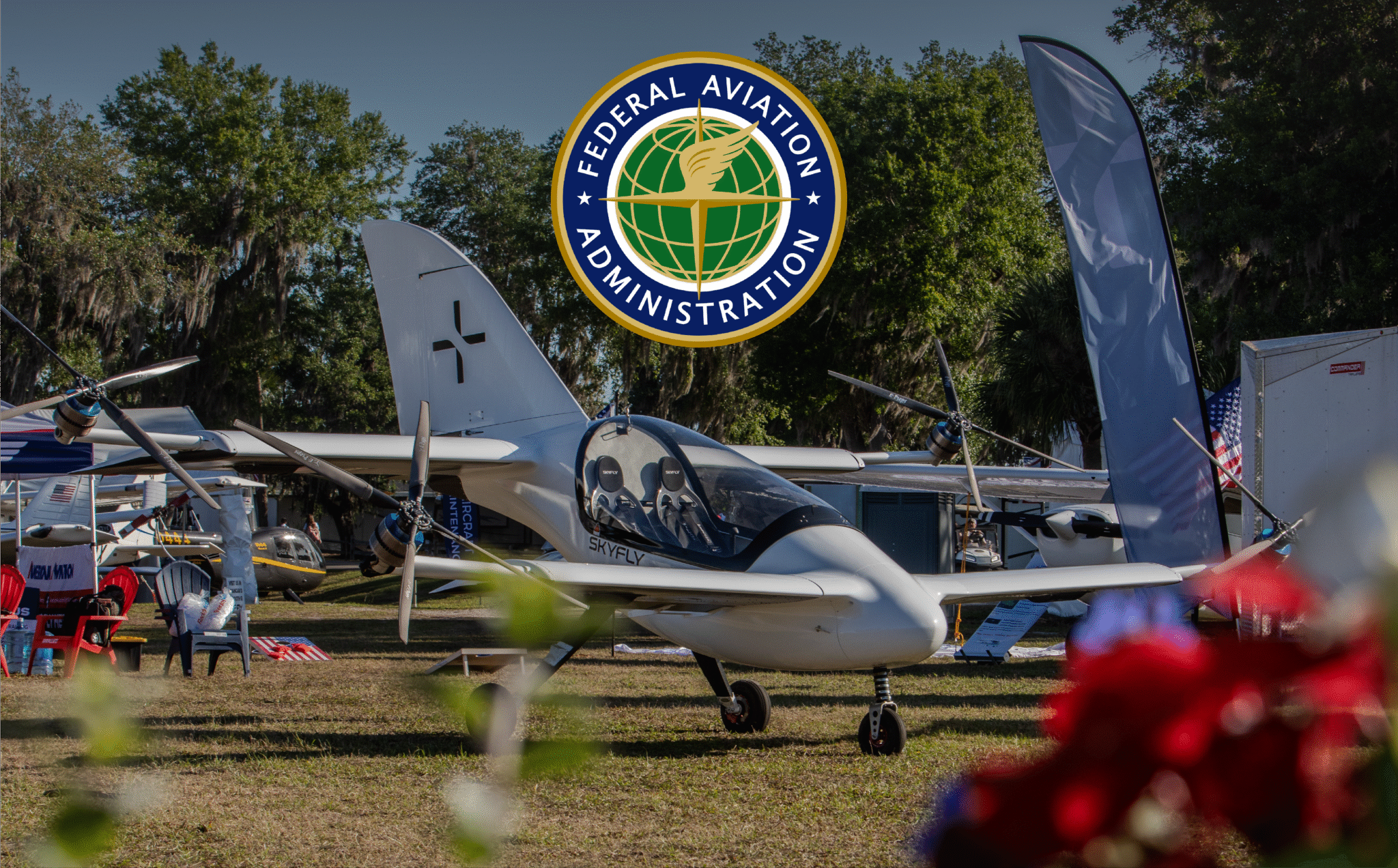 FAA emblem reading 'Federal Aviation Administration' hovering above a display of small aircraft at an outdoor airshow/aviation event.