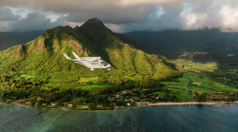 Small white airplane labeled SURFAIR flying over lush green tropical mountains and a coastal shoreline.