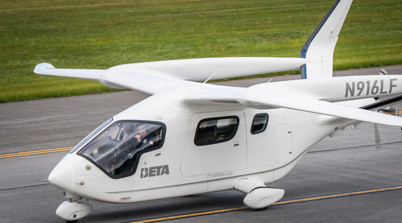 White small aircraft on a runway with two pilots visible in the cockpit and tail number N916LF on the fuselage.