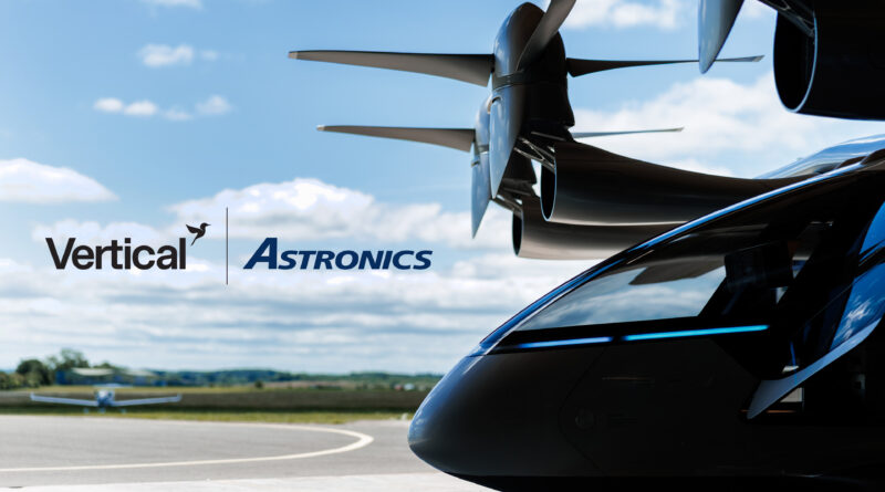 Close-up of a helicopter nose with rotor hub above and the Vertical Astronics logo on the fuselage against a blue sky.