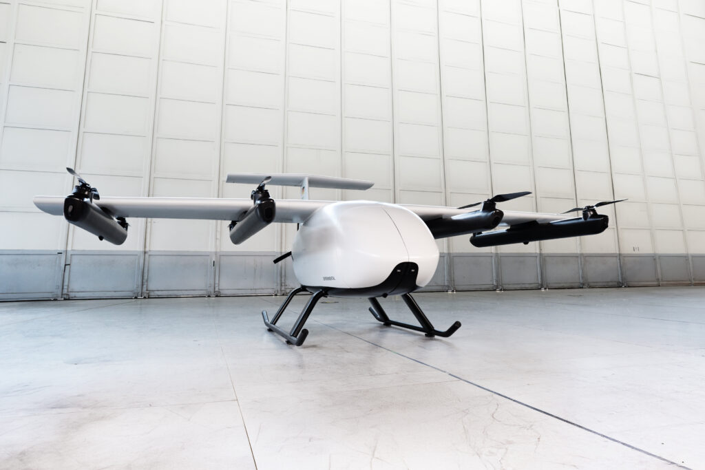 Victor U250 4 - eVTOL Insights White quadcopter drone with landing gear resting in a clean, empty hangar.