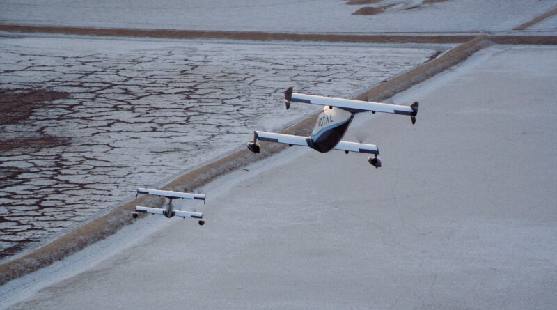 Three light aircraft in formation over a cracked salt flat landscape.