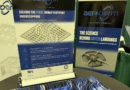 unnamed 51 - eVTOL Insights Display of Aeroberm posters at a tech booth with the slogan 'The Science Behind Safer Landings' on blue panels and a blue wavy grid model on the table.