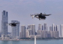 unnamed 52 - eVTOL Insights Two futuristic eVTOL aircraft flying over a city skyline by the water at dusk/dawn light.