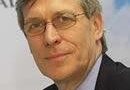 Michael Proffitt Vertiports UK - eVTOL Insights Portrait of a middle-aged man in a dark suit and glasses, looking slightly to the left.