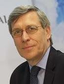 Portrait of a middle-aged man in a dark suit and glasses, looking slightly to the left.