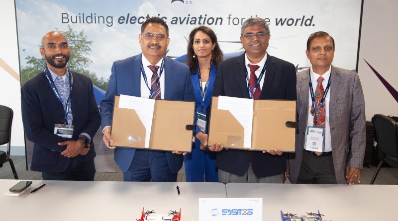 2 - eVTOL Insights Five professionals in business attire stand behind a table holding large folders, posing for a group photo at an aviation event.