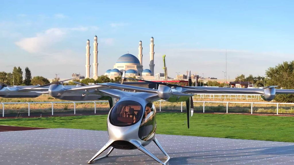Small silver aircraft on a tarmac, with a blue-domed mosque visible in the distance under a clear sky.