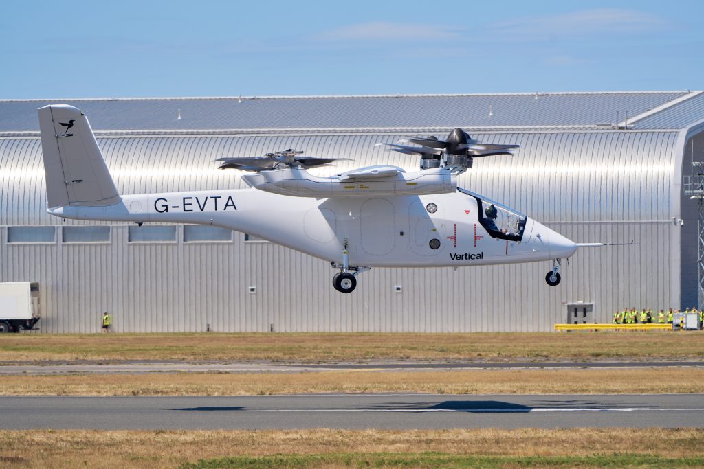 White V-22 Osprey with folded rotors on the taxiway beside a corrugated hangar; tail number G-EVTA.