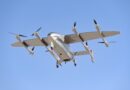 LODD Hili-41 - eVTOL Insights Tilt-rotor aircraft in flight viewed from below, four propellers spinning and landing gear visible against a clear blue sky