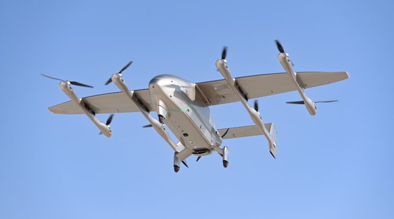 LODD Hili-41 - eVTOL Insights Tilt-rotor aircraft in flight viewed from below, four propellers spinning and landing gear visible against a clear blue sky