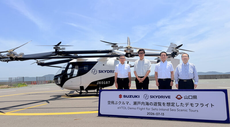 Four men in white shirts stand beside a SkyDrive eVTOL helicopter on a runway, with a promotional sign in front about Seto Inland Sea tours (dated 2026-07-13).