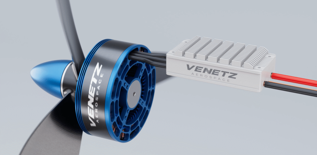 Venetz Aerospace Integrated Propulsion System - eVTOL Insights Close-up of an aerospace electric propulsion motor (blue hub) connected to a white control unit labeled Venetz Aerospace with black cables linking them.