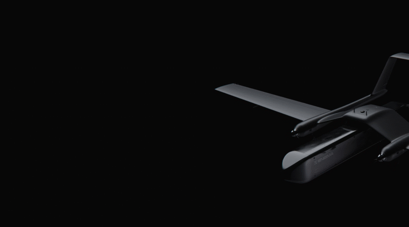 Dark, minimal photo of a sleek drone visible on the right against a black background, showing its wings and propellers.