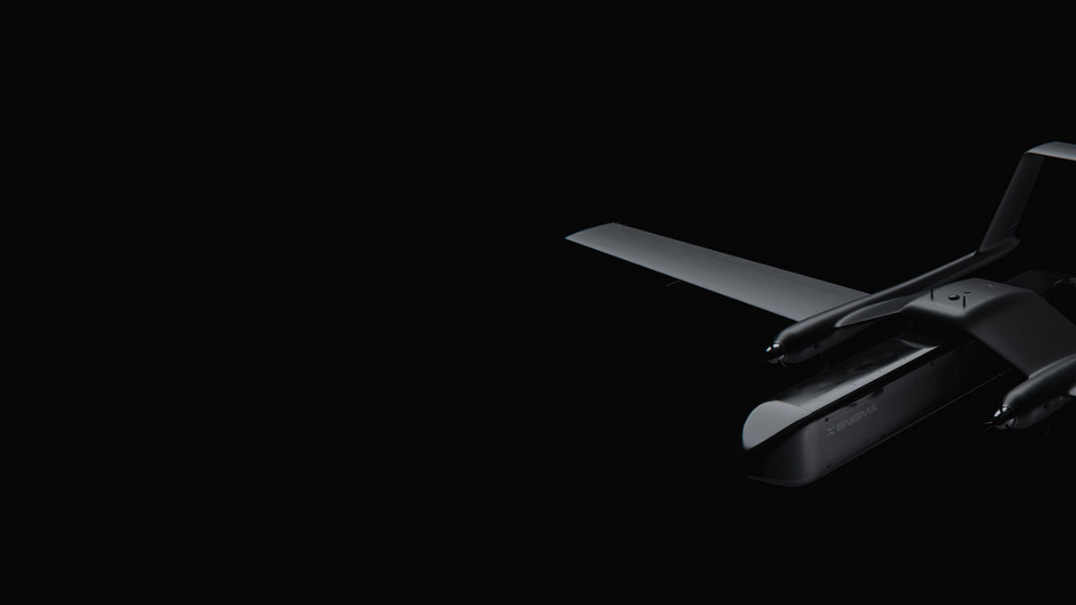 Dark, minimal photo of a sleek drone visible on the right against a black background, showing its wings and propellers.