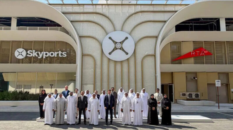 Group of men and women in traditional white kanduras and black abayas pose for a photo in front of a modern building with Skyports signage and a central circular logo.