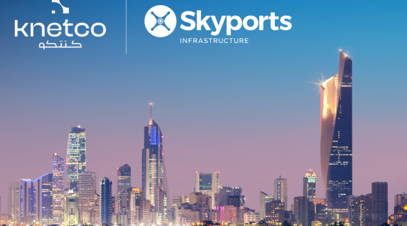 Brand logos above a nighttime city skyline reflected on calm water; Knetco on the left and Skyports Infrastructure on the right via a vertical divider.