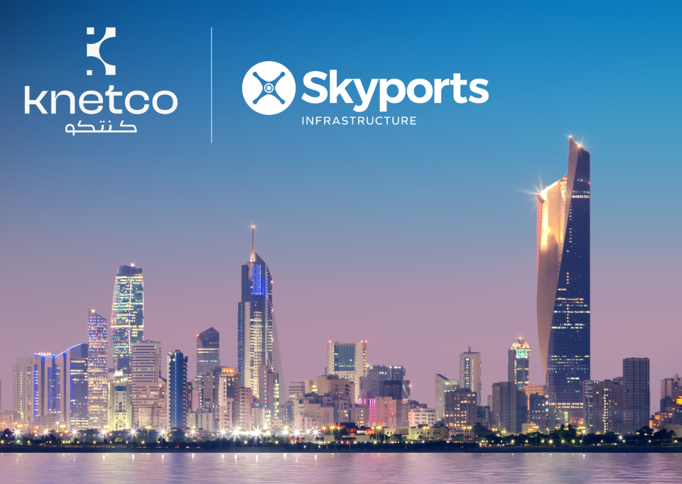 Brand logos above a nighttime city skyline reflected on calm water; Knetco on the left and Skyports Infrastructure on the right via a vertical divider.