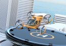Orange quadcopter drone perched on a circular rooftop landing pad with a cityscape and ocean in the background